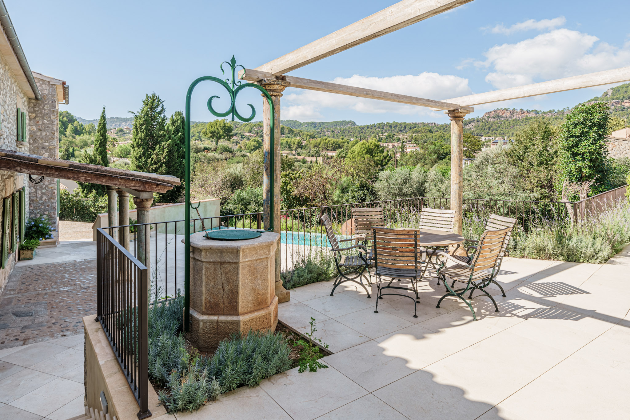 An image of a newly built home with charm in Es Capdella, featuring a harmonious blend of modern design and traditional Mediterranean style. The house boasts a warm and inviting atmosphere with natural materials such as stone and wood, complemented by sleek, contemporary finishes. Large windows allow for plenty of natural light, while the spacious open-plan interiors offer comfort and elegance. The outdoor area includes beautifully landscaped gardens, a private pool, and a large terrace, perfect for enjoying the serene surroundings of this peaceful village