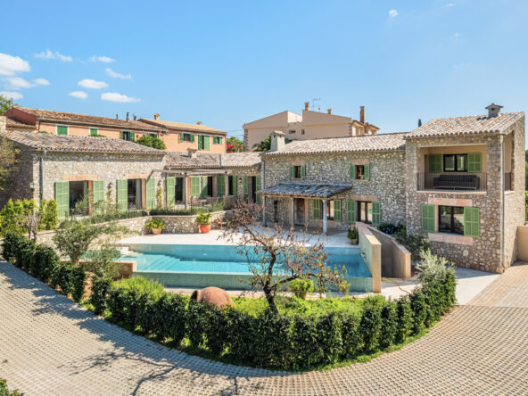 An image of a newly built home with charm in Es Capdella, combining modern design with traditional Mediterranean elements. The house features clean lines, large windows, and a seamless integration with its natural surroundings. Inside, the home boasts an open layout with high-end finishes, creating a bright and inviting atmosphere. The property includes a well-manicured garden, a private pool, and outdoor living spaces, offering both luxury and comfort in the peaceful, picturesque village of Es Capdella.