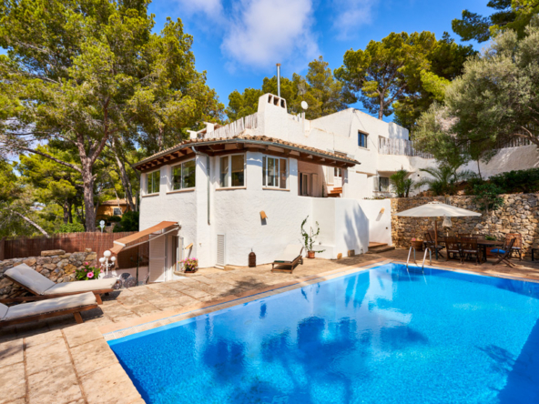 An image of an Ibizan-style villa with charm in Portals Nous, featuring a stunning blend of rustic and contemporary design. The villa showcases whitewashed walls, terracotta floors, and natural materials that capture the essence of Mediterranean living. Large windows and open spaces create a light-filled interior, while the outdoor area includes a beautiful garden, a private pool, and inviting terraces perfect for relaxation and entertaining. The villa’s serene atmosphere and stylish charm make it an ideal retreat in the prestigious Portals Nous area.