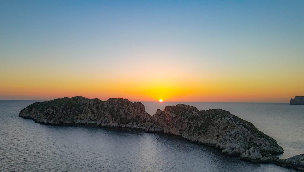 Golden sunset sky casting beautiful colors over the Malgrat Islands in Mallorca.