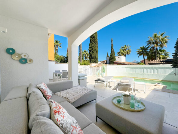 An image of a beautiful Torre-style house in Abubillas, showcasing its traditional Mediterranean charm. The home features rustic stone walls, arched doorways, and a signature tower element that adds character to its design. Surrounded by a lush garden filled with vibrant flowers and mature trees, the house exudes warmth and elegance. The sunlit setting highlights its unique architecture, blending timeless appeal with natural beauty.