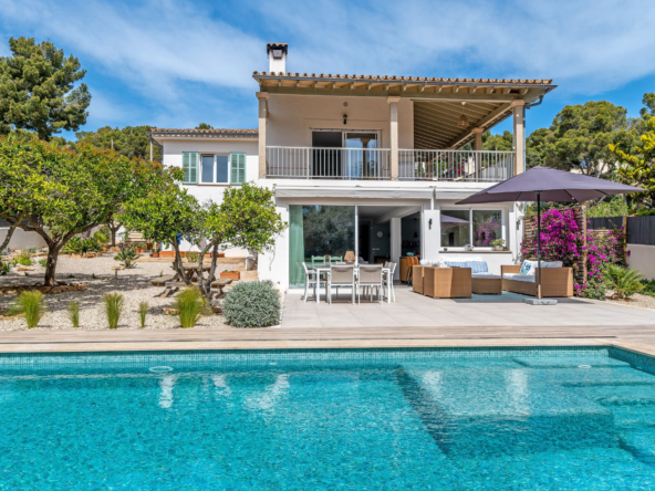 An image of a traditional house that has been beautifully renovated, featuring a charming blend of classic and modern architecture. The house is surrounded by a well-maintained garden with lush greenery and vibrant flowers. In the foreground, a sparkling blue swimming pool reflects the sunlight, adding a touch of luxury to the serene outdoor setting.